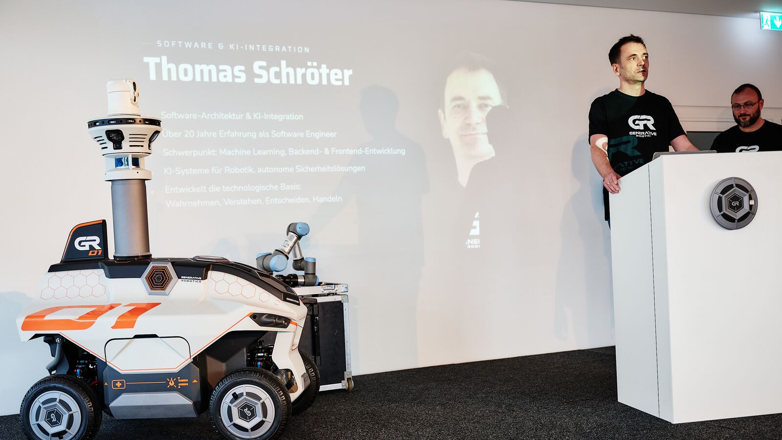 Thomas Schröter at the lectern in front of his name slide, on the left of the stage the GR-01