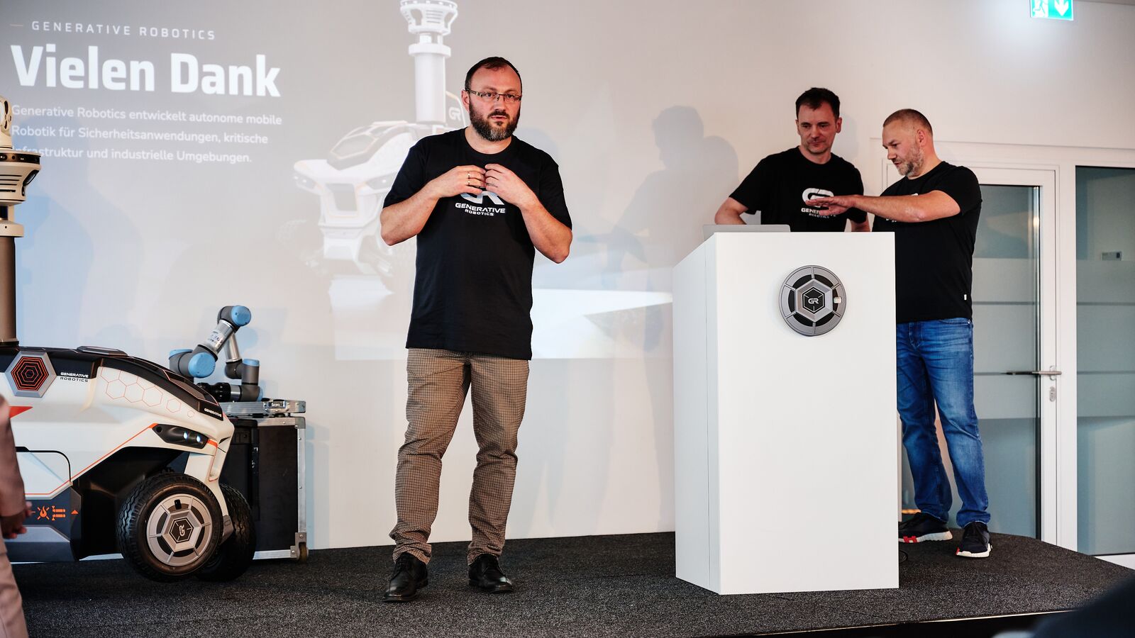 Aleksej Tokarev speaks on stage, at the lectern Thomas Schröter and Andreas Ciborius, on the left the GR-01